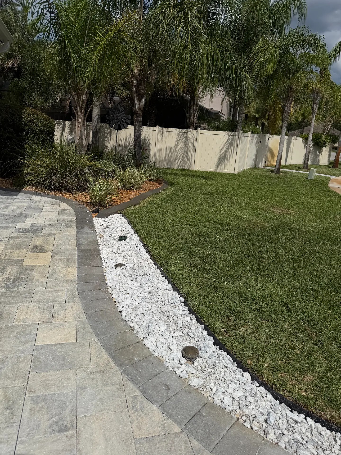 Paver walkway with fresh white rock border after landscaping