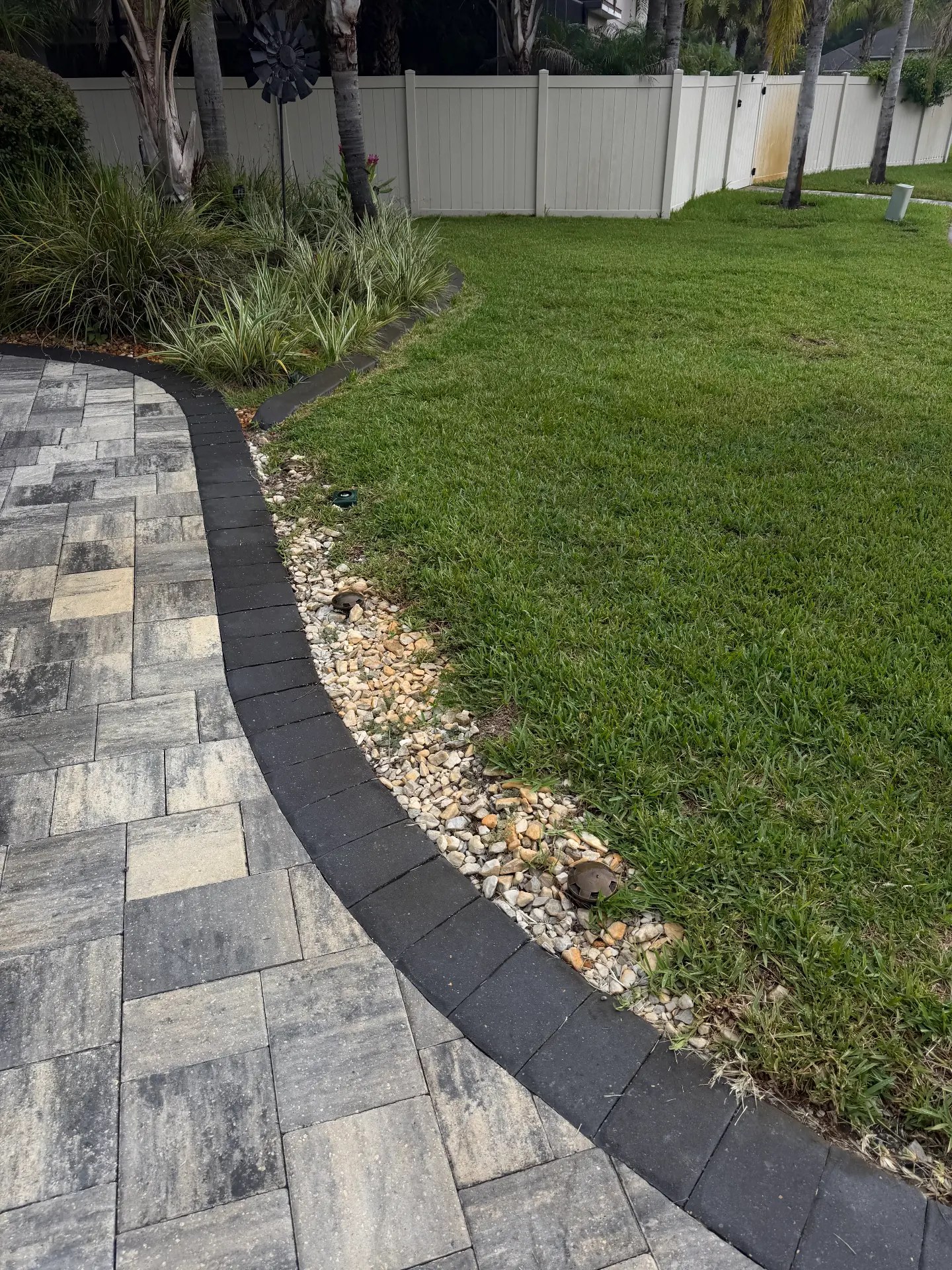 Paver walkway with river rock border before refresh